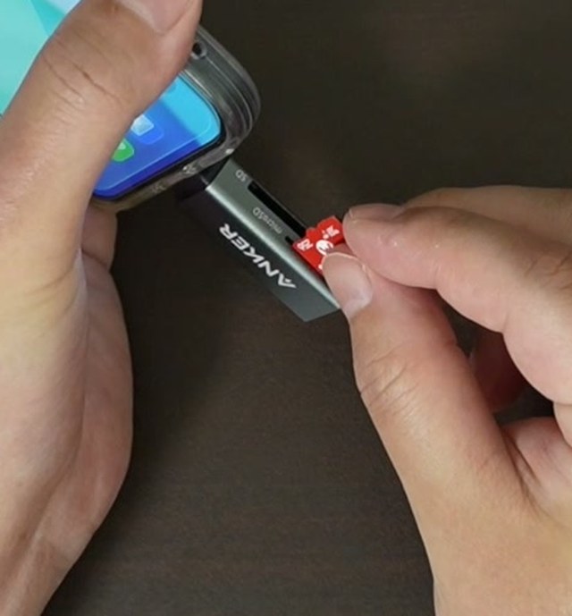 SDカードをカードリーダーの差込口に差し込んでいるところ